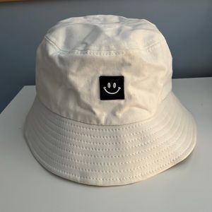 White bucket hat with smiley face.
